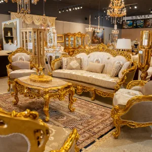 Luxurious Living Room photo featuring the Niccoline Louis XVI Living Room Sofa, chairs, and coffee table in gold leaf and light fabric taken at an angle.